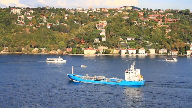 An oil chemical tanker cruising along the Bosporus Sea. Kandilli district with luxury mansions has sea view on the coastline. 