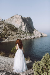 stylish bride with an open back that goes on the mountain with a beautiful view
