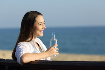 Woman holding a bottle of water on the beach