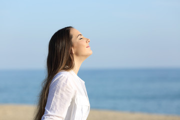 Woman relaxing breathing fresh air on the beach