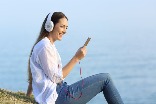 Woman listening to music relaxing on the beach