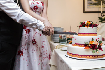 Bride and groom cuts with knife white big beautiful wedding cake