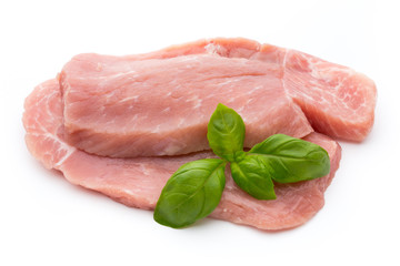 Fresh pork fillet with basil on a white background.