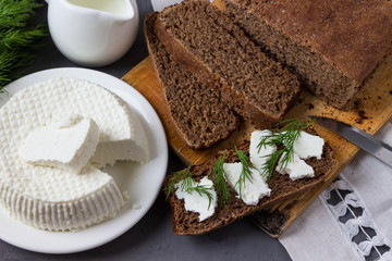 Sandwiches: homemade bread with  cottage cheese and fresh dill on the table.