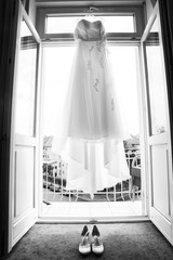 Delicate lace fabric of white long wedding dress and shoes