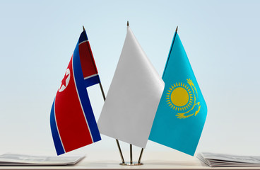 Flags of North Korea and Kazakhstan with a white flag in the middle