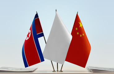 Flags of North Korea and China with a white flag in the middle