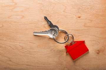 Real estate concept, key chain and keys on wooden background
