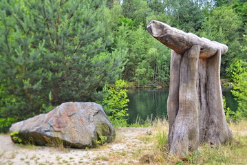 Art in nature - wooden animal next to a stone