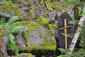 Yellow cross in wooden case at stones in a forest