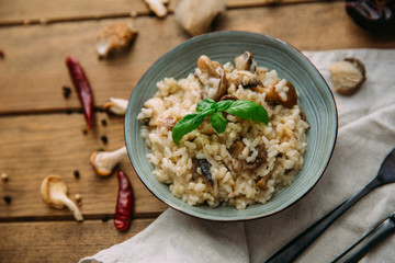 Risotto with mushrooms on an old wooden background. Rustic style.