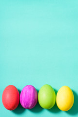 Colorful Easter eggs on green pastel background