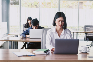 Businesswoman working on notebook computer and business document at office