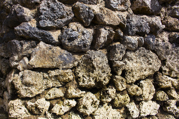 Rough stone solid wall closeup photo. Stone wall texture. Rustic stone wall of ancient building.
