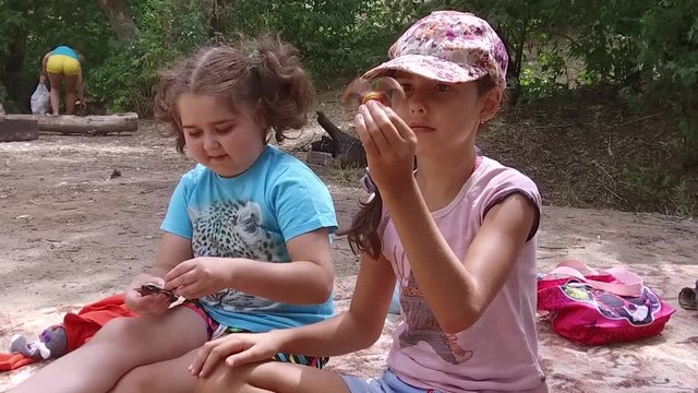 children play with spinners. kids girls scouts spin spinners on vacation slow motion video outdoors
