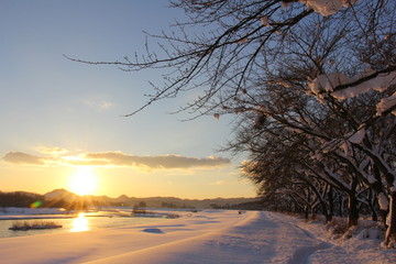 川と日没　冬　雪景色　太陽　青空　夕日　秋田県