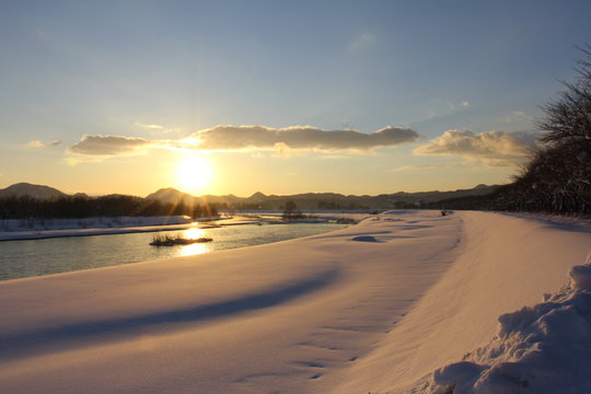川と日没　冬　雪景色　青空　太陽　秋田県