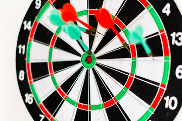 A dartboard target with darts on a white blurred background.