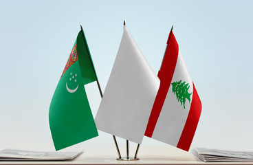 Flags of Turkmenistan and Lebanon with a white flag in the middle