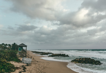 windy cloudy morning at the beach with lifeguard tower and pier in the background