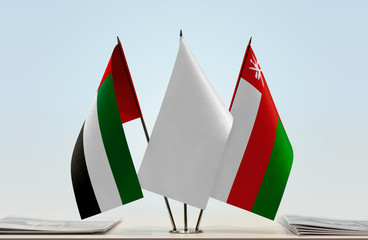 Flags of UAE and Oman with a white flag in the middle
