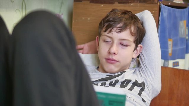 boy teenager conjunctivitis eyes. boy teenager reads book sick conjunctivitis