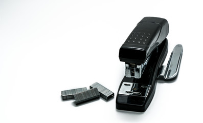Black stapler and staples that have been used in the office for a long time. Black stapler and staples on white background with copy space. Old staff of the office and valuable personnel concept.