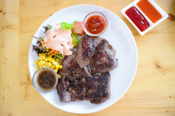 Big beef steak eat with vegetable corn salad on a white plate
