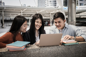 Group of students studying researching on laptop Together sitting at college.