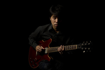 Obraz na płótnie Canvas asian young musician playing guitar