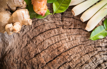 Galangal, ginger, kaffir lime leaves, lemon grass placed on old wooden background