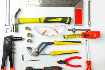 Set of construction tools on white background as wrench, hammer, pliers, socket wrench, spanner, tape measure, electric drill,safety glasses, screwdriver