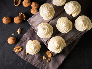 Carrot cupcakes or muffins with nuts on dark background
