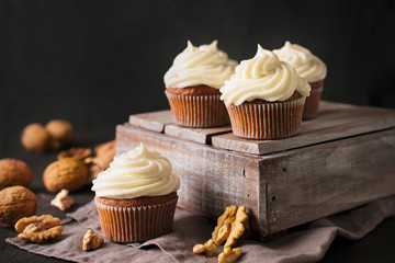 Carrot cupcakes or muffins with nuts on dark background
