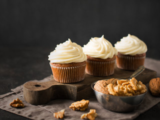 Carrot cupcakes or muffins with nuts on dark background