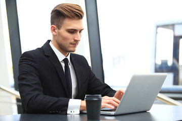 Young adult using laptop in airport lounge