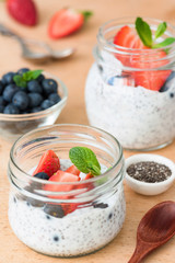Chia seed pudding with fresh strawberries and blueberries on wooden table. Selective focus. Concept of dieting, clean eating, healthy lifestyle and weight loss food
