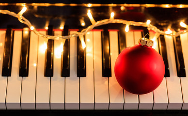Christmas ball and lights on a piano keyboard, above view