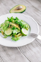 Healthy food green salad with cucumbers and avocado in a plate