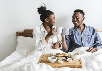 A couple having breakfast in bed - obrazy, fototapety, plakaty