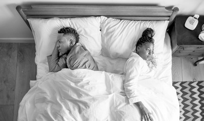 African American couple sleeping back to back