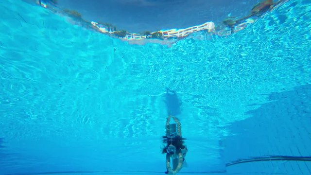girl swims underwater in the pool