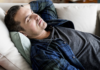 Fototapeta premium Caucasian man sleeping on the couch