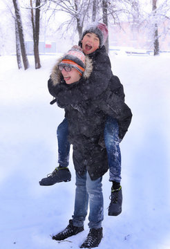 two teenager bpy having winter fun playing on snowfall park