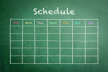 Schedule with grid timetable on green chalkboard