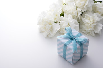 青色のギフトボックスと白いカーネーション