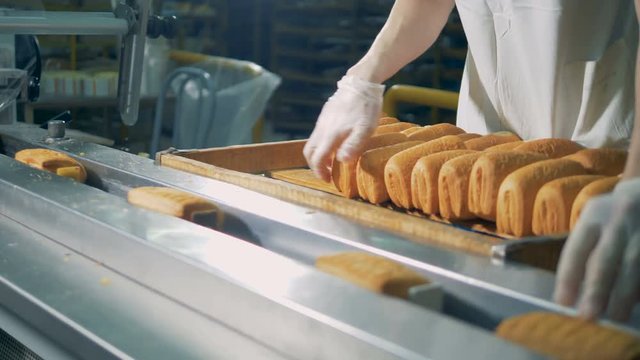 A worker pastry by hand for film wrapping. 