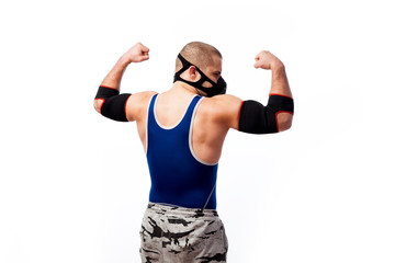 Fototapeta na wymiar Young sporty man in blue tights, black training mask and black elbow pads is standing with his back and showing biceps on white isolated background