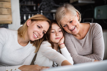 A small girl with mother and grandmother at home.