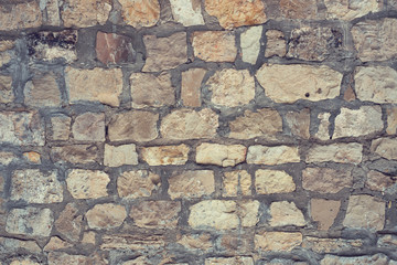 Gray decorative uneven cracked stone wall surface with cement